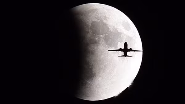 Một chiếc máy bay đang bay phía trước “Supermoon” trên bầu trời Geneva, Thụy Sĩ.