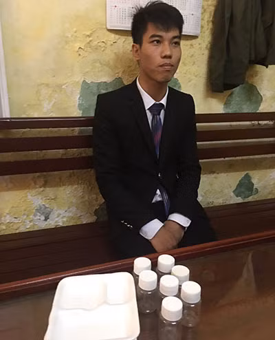 Đối tượng Nguyễn Hoàng Trung và lọ đựng “nước thánh”.