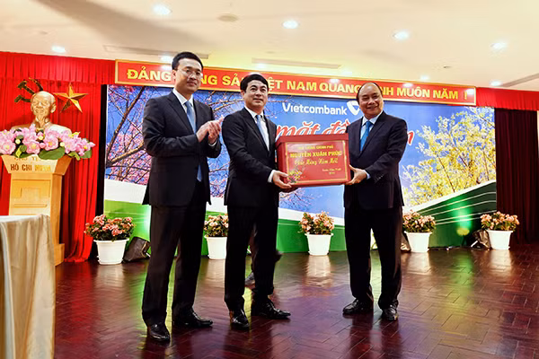 Đồng chí Nguyễn Xuân Phúc - Uỷ viên Bộ Chính trị, Thủ tướng Chính phủ (bên phải) tặng quà cho Ban Lãnh đạo và tập thể CBNV Vietcombank