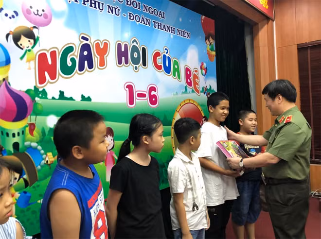 Thiếu tướng Nguyễn Thanh Sơn, Phó Cục trưởng Cục Đối ngoại trao quà cho các cháu con của cán bộ, chiến sĩ Cục.