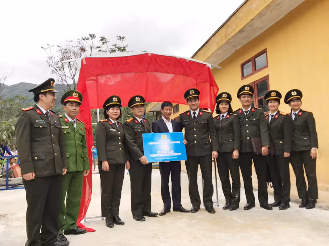 Đại tá Nguyễn Quốc Lam, Phó Viện trưởng Viện Khoa học và Công nghệ trao số tiền ủng hộ làm sân vui chơi cho học sinh điểm trường Suối Ún.