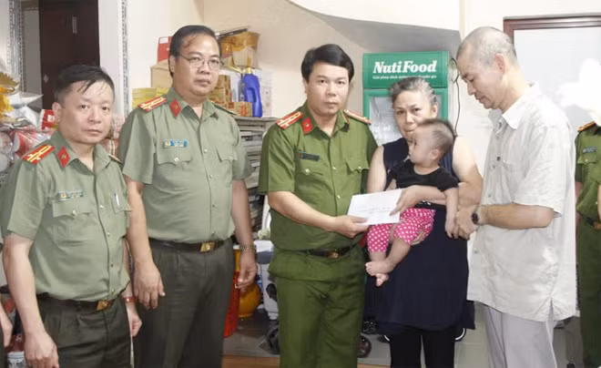 Đại tá Hoàng Quốc Việt, Phó Giám đốc Công an tỉnh Sơn La trao số tiền 56 triệu đồng cho gia đình Liệt sĩ Phạm Công Huy.