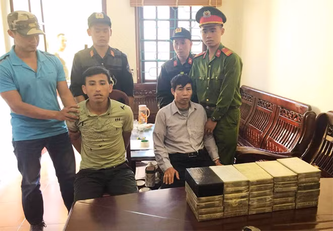 Hờ A Dà ( ngồi trái), Phạm Minh Châu (ngồi phải) cùng tang vật 30 bánh heroin.