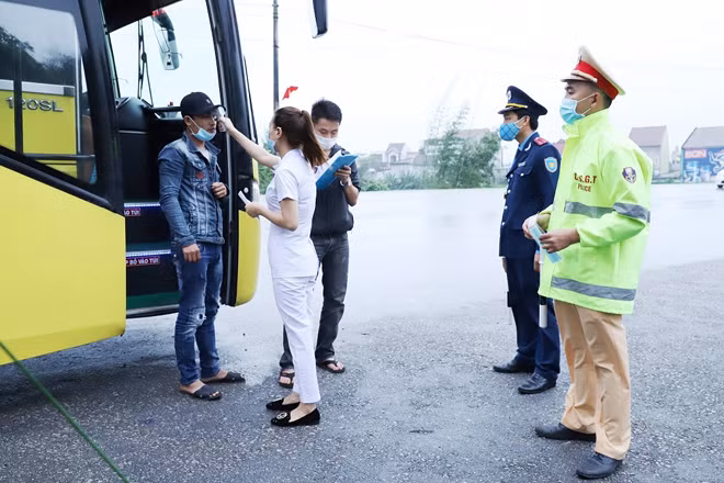 phối hợp đo thân nhiệt và phát khẩu trang cho những người tham gia giao thông.