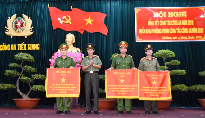 Đại tá Nguyễn Văn Nhựt, Giám đốc Công an tỉnh Tiền Giang trao cờ của Bộ Công an tặng “đơn vị dẫn đầu phong trào thi đua cấp cơ sở”.