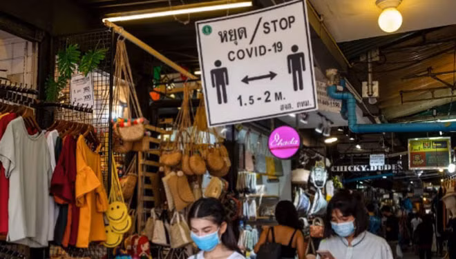 Những người mua sắm tại Chợ Chatuchak – Bangkok đeo khẩu trang và tuân thủ theo biển báo giữ khoảng cách xã hội.