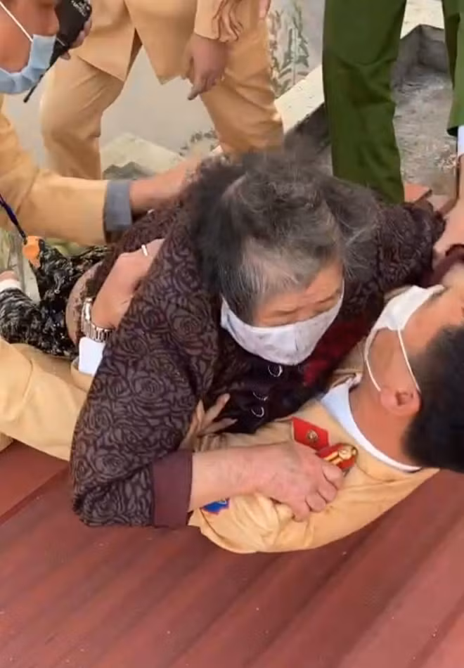 Lực lượng Công an đã nổ lực đưa cụ bà bị mắc kẹt ra khỏi đám cháy.