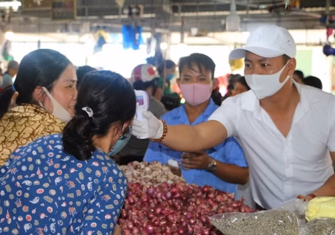 Tiểu thương chợ Phú Bài được kiểm tra thân nhiệt ngay tại chợ.