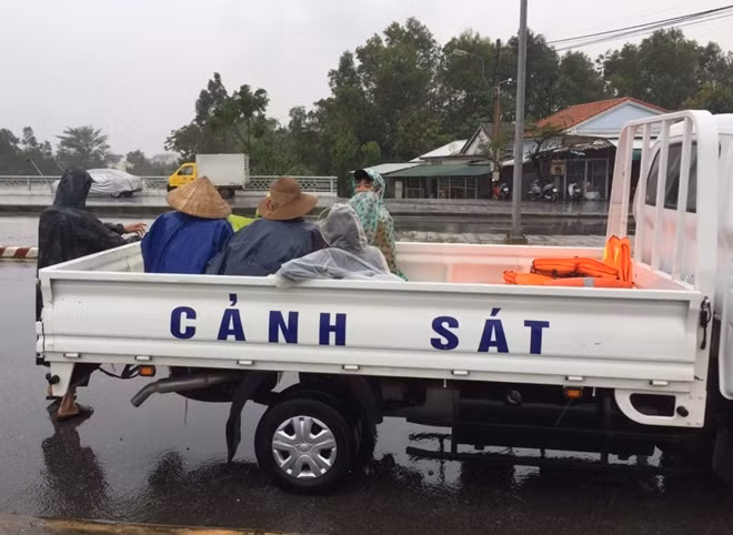 Người dân được chở trên xe Cảnh sát đưa từ vùng ngập lụt đến nơi an toàn.