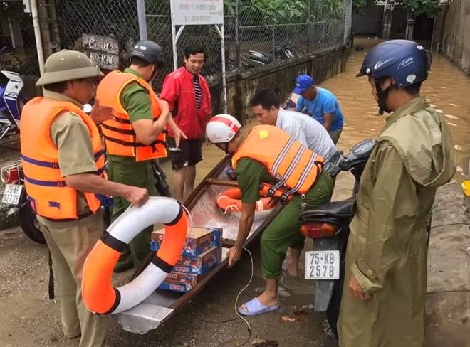 Lực lượng Công an sử dụng ghe đò tiếp cận các hộ dân ở vùng ngập lũ để hỗ trợ nhu yếu phẩm.