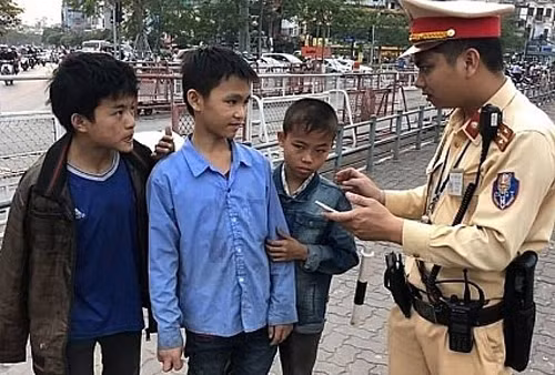 Anh CSGT đang hỏi chuyện 3 em nhỏ bị lạc.