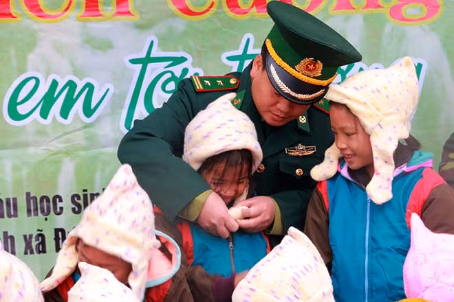 Trung tá Nguyễn Đình Tân, Đồn trưởng Đồn Biên phòng Cốc Pàng, BĐBP Cao Bằng trao quà cho các em học sinh. Ảnh: Quang Long.