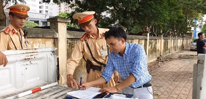 Người vi phạm giao thông ký vào biên bản xử phạt.