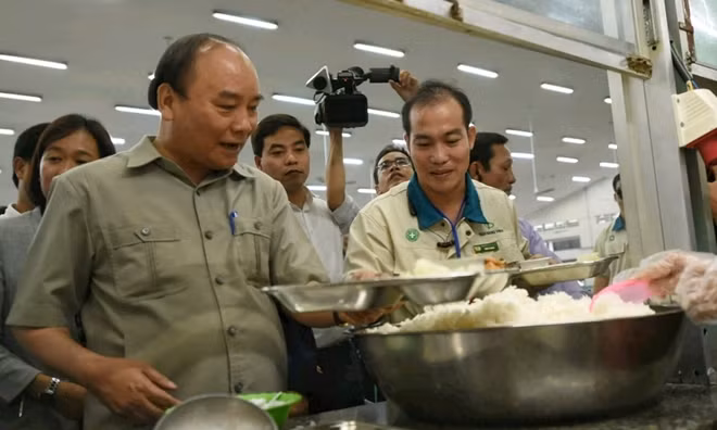 Thủ tướng cùng các công nhân lấy suất cơm ca chiều. - Ảnh: VGP/Quang Hiếu