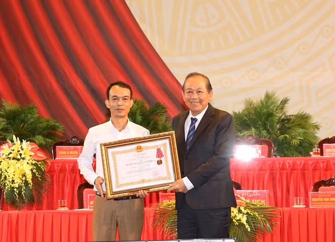 Thay mặt lãnh đạo Đảng và Nhà nước, Phó Thủ tướng Trương Hòa Bình trao Huân chương Lao động hạng Ba cho cán bộ, công chức Phòng Dân tộc huyện Kim Bôi. Ảnh: VGP/Lê Sơn