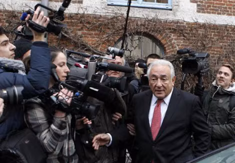 Cựu Tổng Giám đốc IMF Strauss-Kahn (ở giữa) đến dự phiên tòa trong vòng vây của báo giới. (Ảnh: AP).