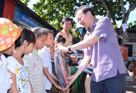 Đồng chí Lê Tấn Thủ - Bí thư huyện ủy Cờ Đỏ trao quà cho các em học sinh.