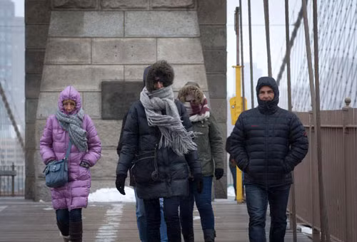 Nhiều người đang đi bộ trên cầu Brooklyn, New York, cơn bão tuyết mùa đông đang bắt đầu tấn công vào thành phố phía đông nước Mỹ.