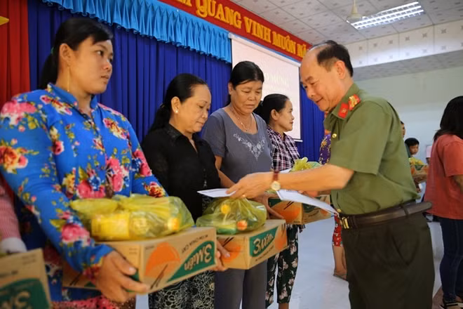 Đại tá Trần Kim Thẩm, Phó Tổng biên tập Báo CAND trao quà Tết cho bà con có hoàn cảnh khó khăn xã Mỹ Hội, huyện Cái Bè.