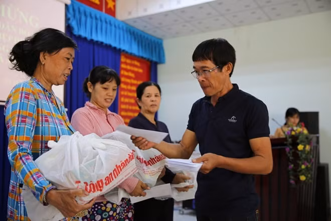 Đại diện các nhà hảo tâm trao quà cho người nghèo.