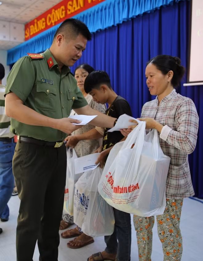 Thiếu tá Nguyễn Văn Bình, Phó trưởng cơ quan đại diện Báo CAND tại TP Hồ Chí Minh trao quà Tết.