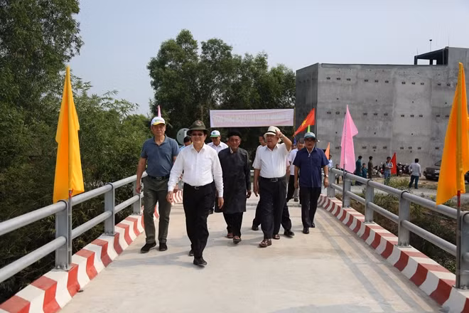 Nguyên Chủ tịch nước Trương Tấn Sang và các đại biểu đi bộ qua cây cầu vừa được khánh thành.