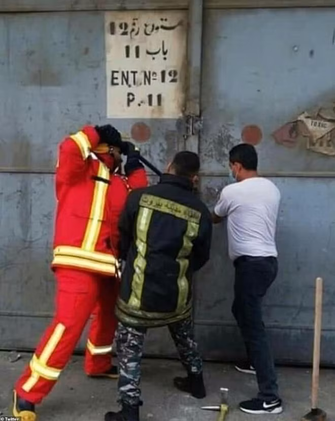 Hình ảnh 3 người lính cứu hoả cố phá nhà kho trước thảm kịch. Trong số họ, có người được huy động đến hiện trường trước khi kịp thay trang phục bảo hộ. Ảnh: DailyMail