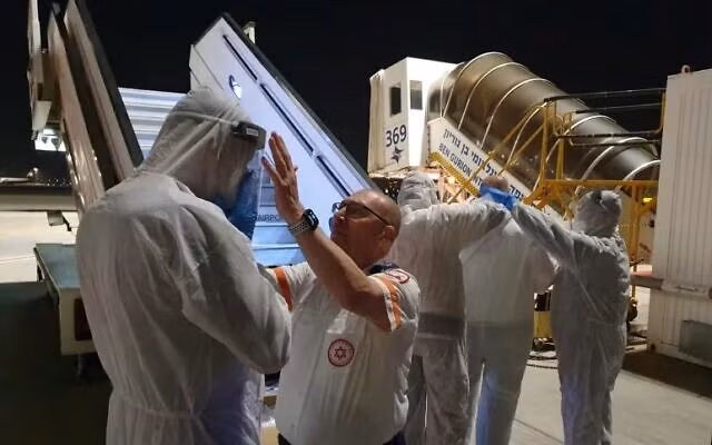 Nhân viên y tế mặc đồ bảo hộ ở sân bay Tel Aviv. Ảnh: TOI