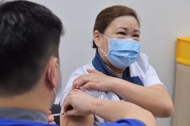 Y tá Sarah Lim tiêm vaccine COVID-19. Ảnh: StraitsTimes