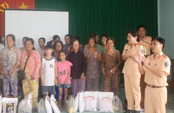 Cảnh sát đường thủy vừa tuyên truyền, vừa tặng quà cho người dân.