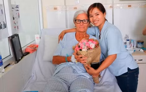 Chị Nguyễn Thị Thông thăm và tặng hoa mừng bà Vidal N. trong ngày xuất viện.