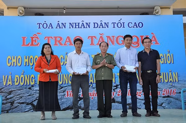 Đại tá Trần Kim Thẩm, Phó Tổng biên tập Báo Công an nhân dân và ông Lâm Tấn Lợi, Giám đốc Công ty TNHH sản xuất Duy Lợi trao tặng quà cho đại diện hai xã Phước Ninh, Phước Nam – huyện Thuận Nam, tỉnh Ninh Thuận.