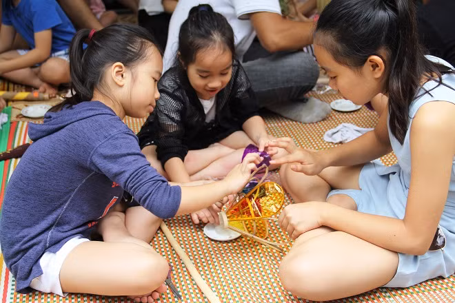 Các em nhỏ trải nghiệm cách làm chiếc đèn ông sư.