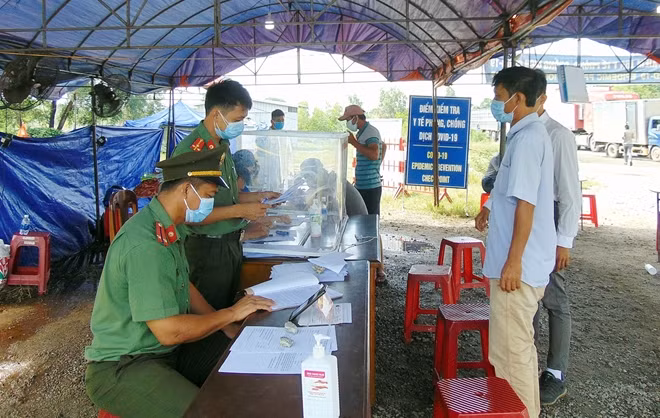 Người dân khai báo y tế tại chốt kiểm soát dịch trên QL1A khu vực dốc Sỏi, huyện Núi Thành.
