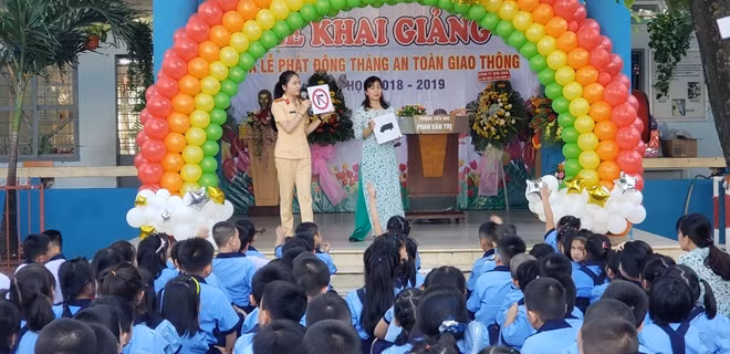 Nữ chiến sĩ CSGT đang tuyên truyền luật giao thông cho các em học sinh
