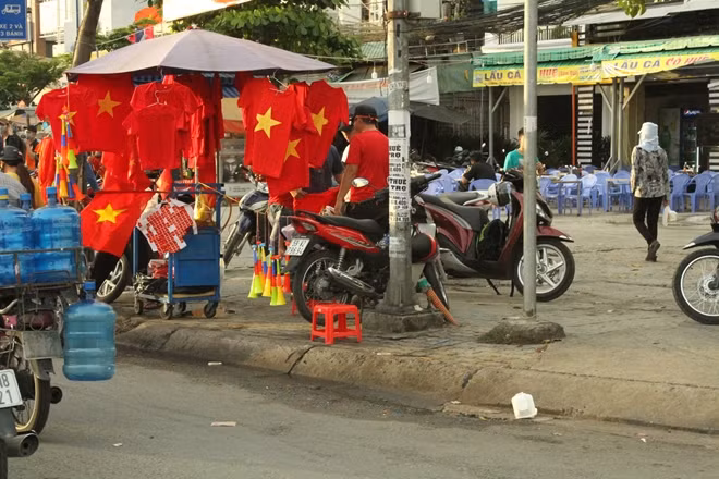 Từ rất sớm, cờ hoa, trang phục cho CĐV cổ vũ đội tuyển Việt Nam được bán khắp nơi trên các tuyến đường TP Hồ Chí Minh