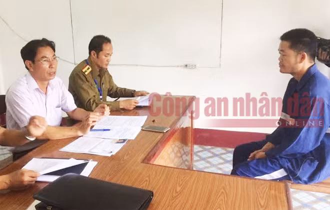Đối tượng Tòng Văn Kiên (mặc bộ xanh ngồi bên phải ảnh) đang khai báo hành vi phạm tội với Công an Lào và đại diện Cảnh sát Việt Nam tại Lào.