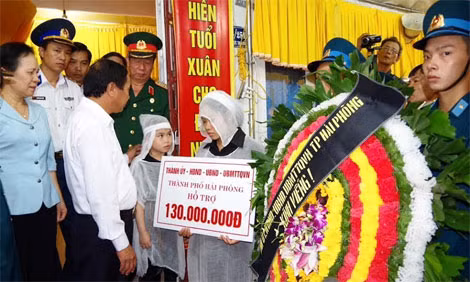 Đồng chí Lê Văn Thành trao 130 triệu đồng của Thành phố cho gia đình liệt sĩ Nguyễn Bá Thế.