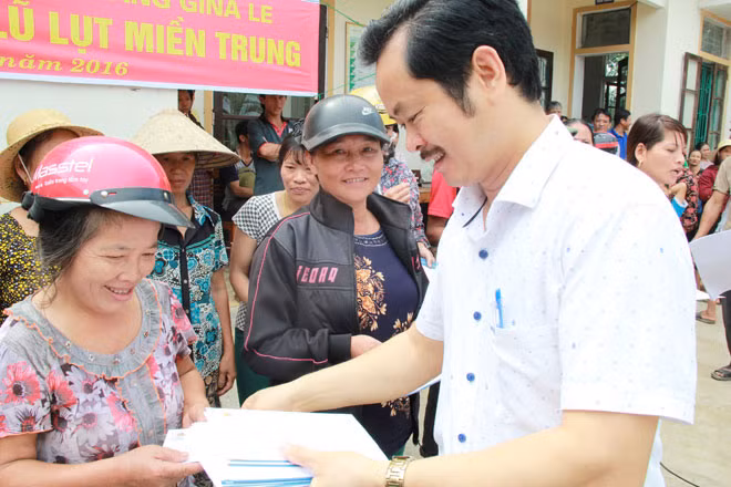Ông Nguyễn Huy Hoàng, Chủ tịch công đoàn Tập đoàn Đầu tư Văn Phú trao quà tới bà con vùng lũ xã Hương Giang.