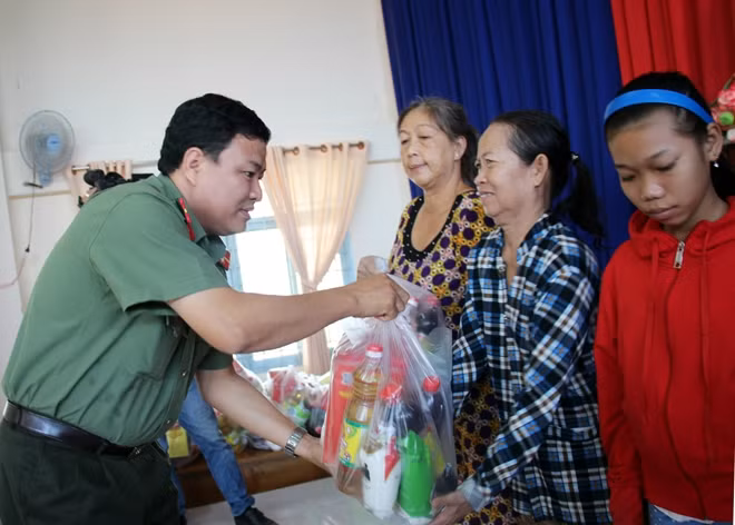 Đại diện Báo CAND trao quà Tết cho bà con có hoàn cảnh khó khăn.