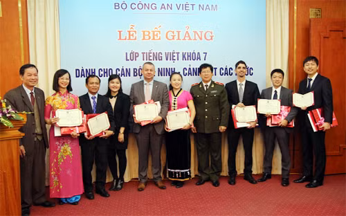 Đại diện Bộ Công an, Bộ Giáo dục và Đào tạo trao giấy chứng nhận cho các học viên Lớp học tiếng Việt khoá VII. Ảnh Vũ Linh.