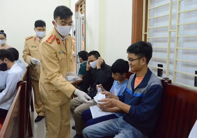 Từng chiếc khẩu trang kháng khuẩn được phát miễn phí cho người dân đến làm thủ tục hành chính.