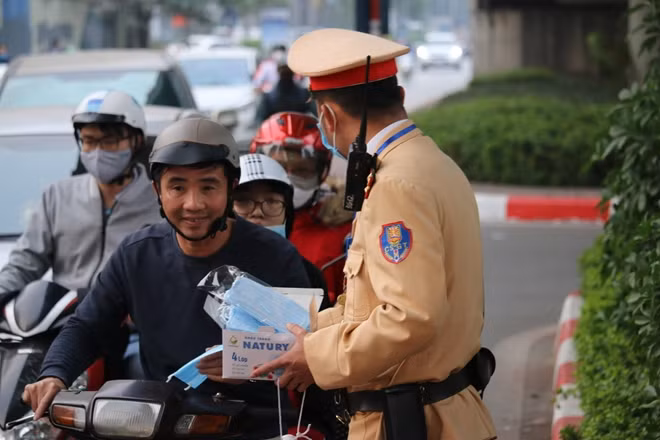 Lực lượng CSGT phát khẩu trang cho người tham gia giao thông.