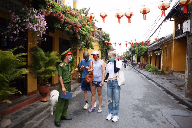 Công an TP Hội An trò chuyện và nhắc nhở du khách người nước ngoài tuân thủ những quy định an toàn phòng, chống dịch COVID-19 khi tham quan và du lịch.