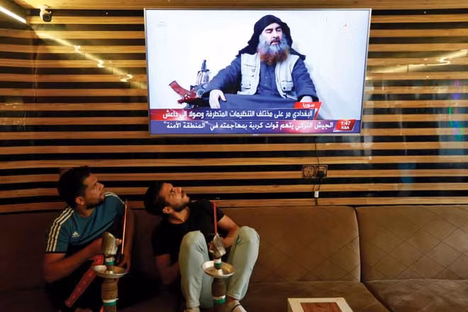 Ngày 27-10: Người dân ở Najaf, Iraq, xem một chương trình tin tức báo cáo về cái chết của thủ lĩnh IS Abu Bakr al-Baghdadi. (Alaa al-Mar camera / Reuters)