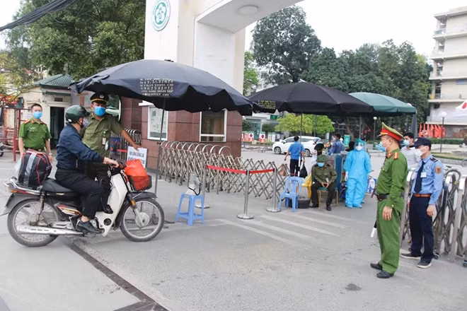 Công an phường Phương Mai phối hợp với bảo vệ bệnh viện tiến hành việc kiểm soát ra vào Bệnh viện Bạch Mai (Hà Nội).