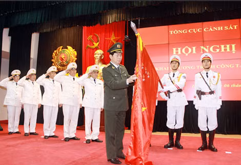 Đại tướng Trần Đại Quang, Ủy viên Bộ Chính trị, Bộ trưởng Bộ Công an gắn Huân chương Quân công hạng Ba lên lá cờ truyền thống của Cục Cảnh sát điều tra tội phạm về ma túy.