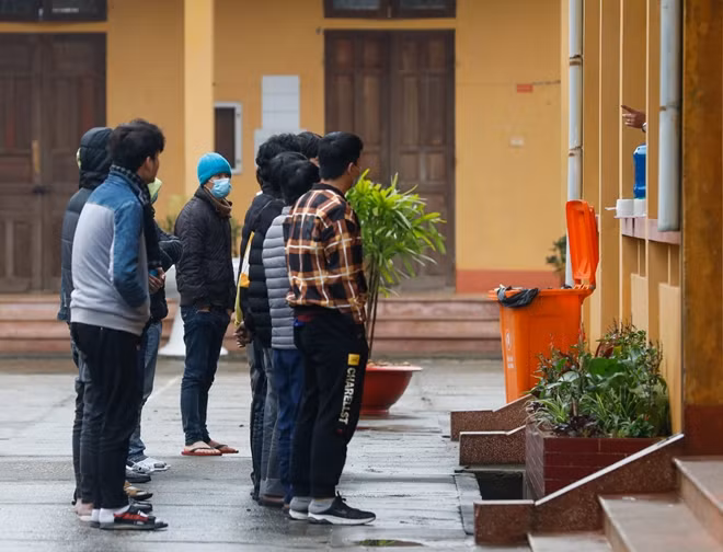 Các công dân xếp hàng nghe phổ biến nội quy cách ly
