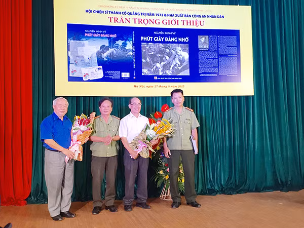 Ông Vũ Mão, nguyên Chủ nhiệm Văn phòng Quốc hội, Đại tá, nhà văn Nguyễn Hồng Thái, Giám đốc NXB CAND và Đại tá, nhà văn Đặng Vương Hưng tặng hoa tác giả Nguyễn Minh Vỹ.