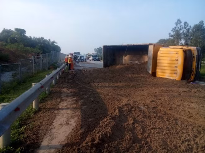 Xe tải chở đất bị lật ngang đường.